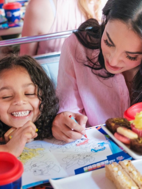 Kids and parents coloring and enjoying treats aboard the Paw Patrol bus.