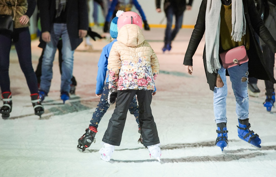 People ice skating at Ovocný trh rink during Christmas in Prague.