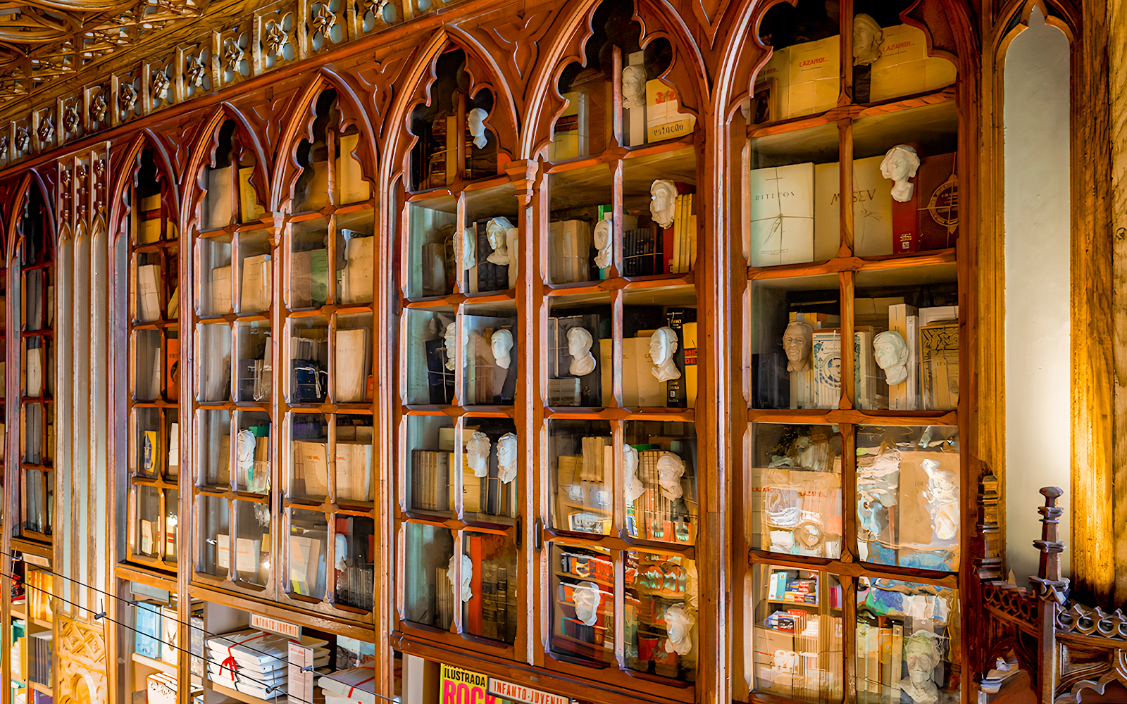 Lello Library interior with ornate wooden bookshelves and busts in Porto, Portugal.