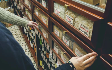 Hands selecting items from a shelf in a Porto food shop during a wine tour.