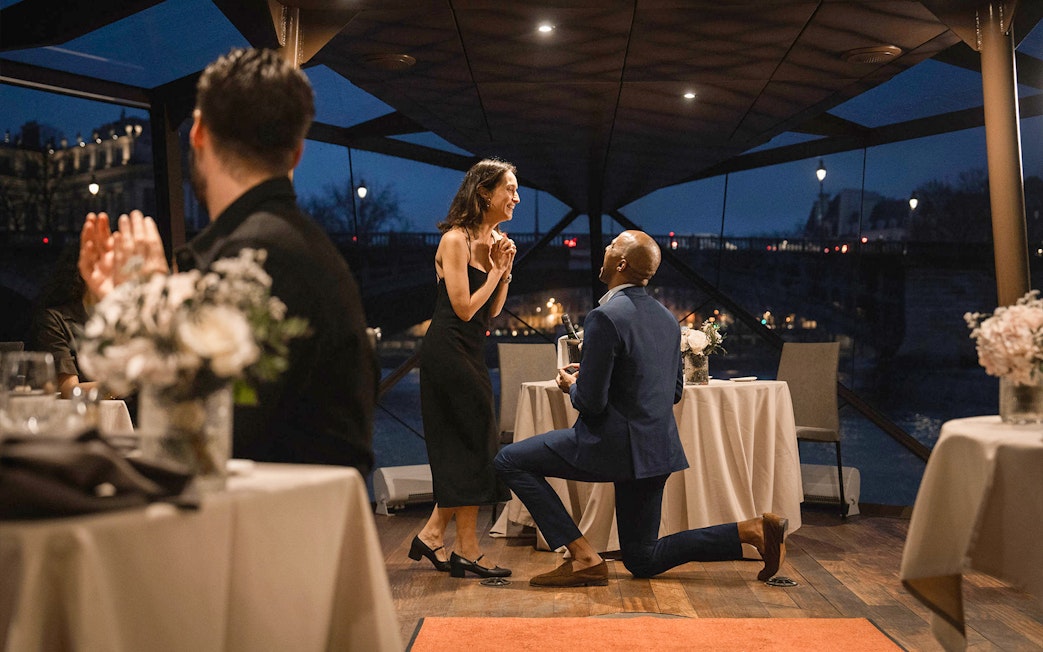 Couple engaged on Bateaux Mouches Seine River dinner cruise in Paris.