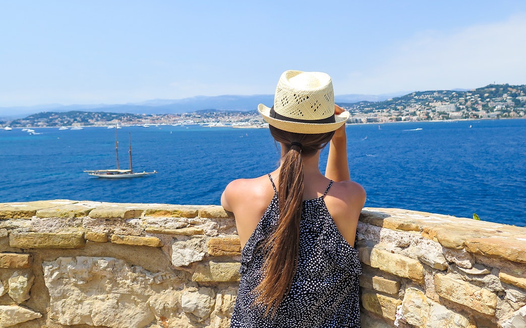 Woman overlooking the sea from Ste. Marguerite Island with Cannes in the background.