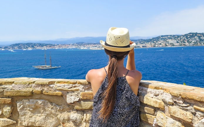 Woman overlooking the sea from Ste. Marguerite Island with Cannes in the background.