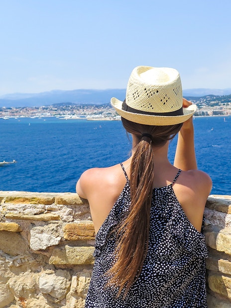 Woman overlooking the sea from Ste. Marguerite Island with Cannes in the background.