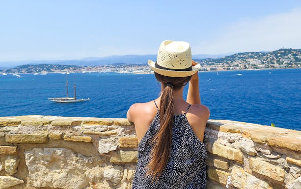 Woman overlooking the sea from Ste. Marguerite Island with Cannes in the background.