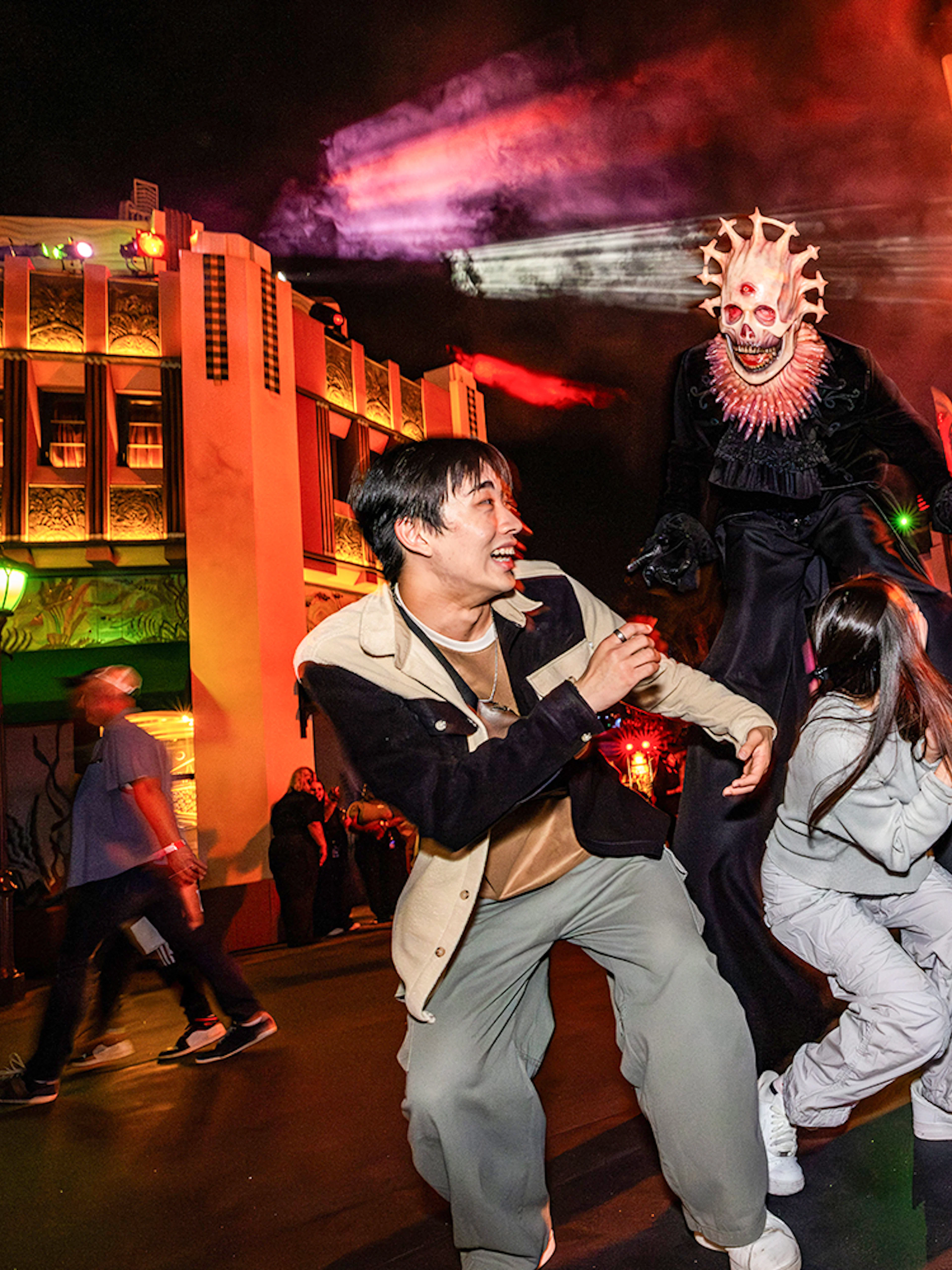 Guests reacting to a costumed performer at Hollywood Horror Nights, Universal Studios Hollywood, Los Angeles.
