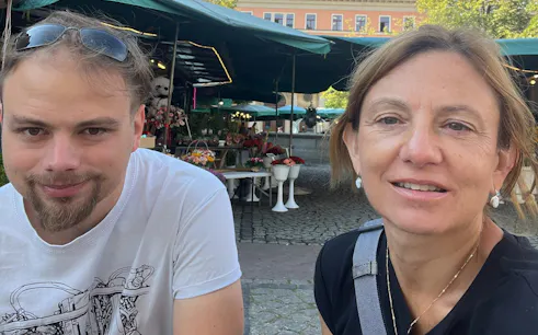 Outdoor market scene in Wroclaw with flower stalls, part of the Old Breslau city exploration game.