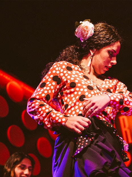 Flamenco dancer performing at Los Tarantos Flamenco Show in vibrant attire.