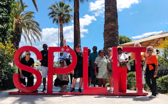 Tourists posing with the Split sign during a city tour in Split, Croatia.