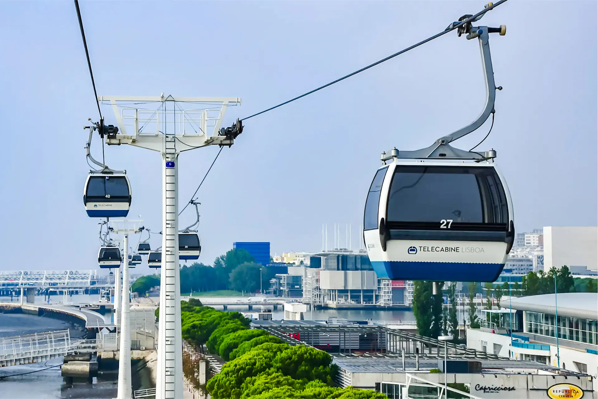 Lisbon cable cars over the Tagus River with cityscape in the background.
