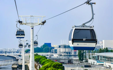 Lisbon cable cars over the Tagus River with cityscape in the background.
