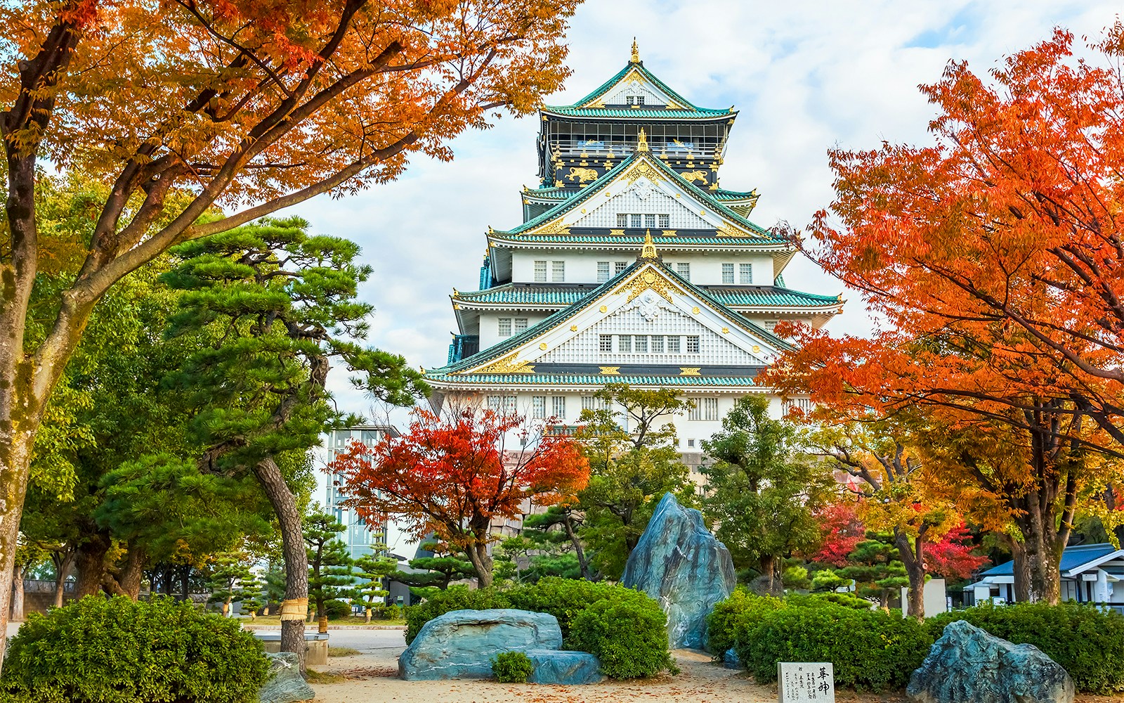 Osaka Castle surrounded by autumn foliage in Osaka, Japan.