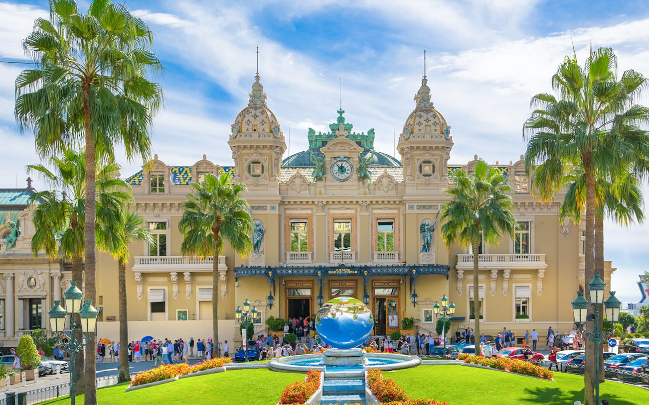 Grand Casino Monte Carlo exterior with ornate architecture and luxury cars, popular tourist attraction.