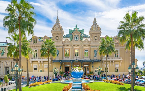 Grand Casino Monte Carlo exterior with ornate architecture and luxury cars, popular tourist attraction.