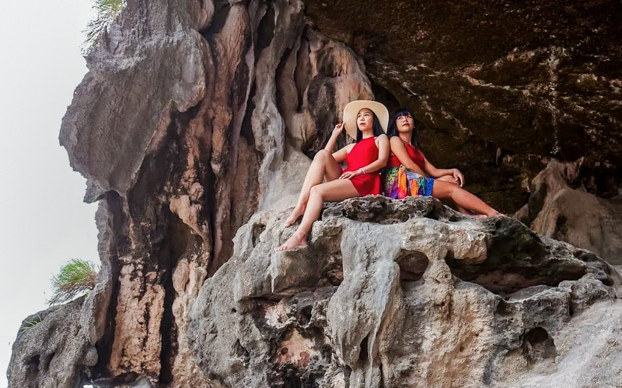 Tourists sitting on limestone formations in a scenic location.