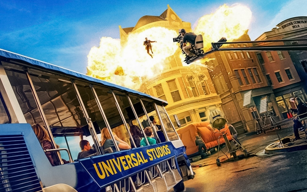 Universal Studios Hollywood tram tour with explosion and film crew on set.