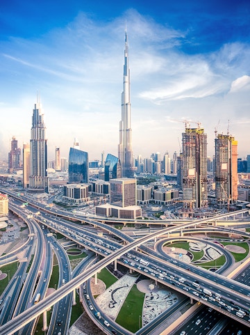 Burj Khalifa towering over Dubai skyline with intricate highway network below.