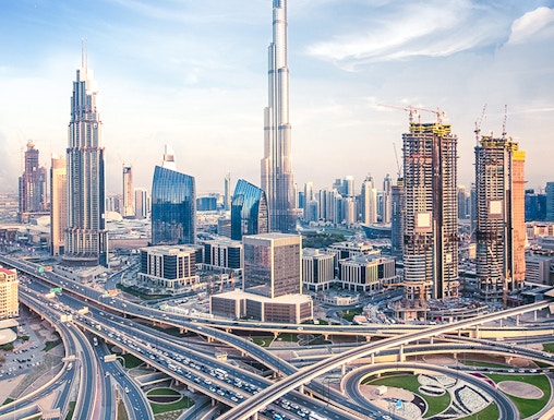 Burj Khalifa towering over Dubai skyline with intricate highway network below.