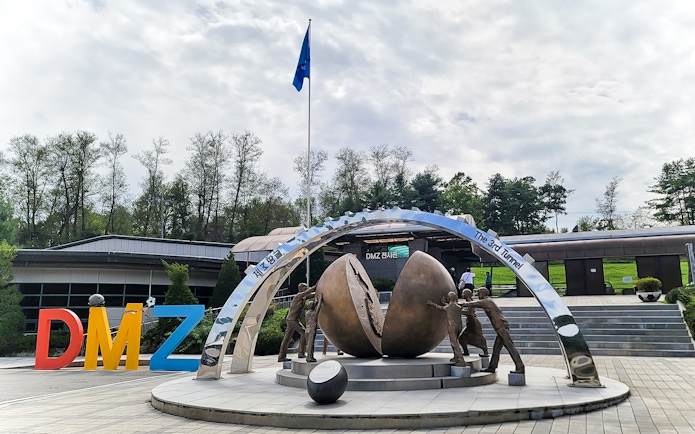 DMZ sculpture with figures pushing a divided sphere, Korean Demilitarized Zone.