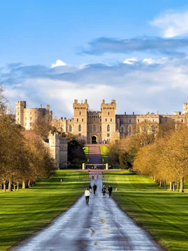 Windsor Castle with visitors walking along the Long Walk path, England.