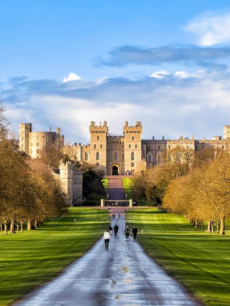 Windsor Castle with visitors walking along the Long Walk path, England.