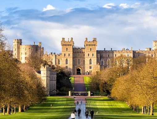 Windsor Castle with visitors walking along the Long Walk path, England.