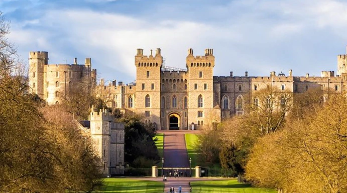 Windsor Castle with visitors walking along the Long Walk path, England.