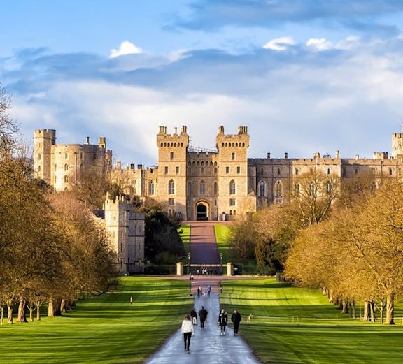 Windsor Castle with visitors walking along the Long Walk path, England.