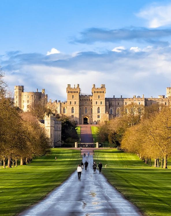 Windsor Castle with visitors walking along the Long Walk path, England.