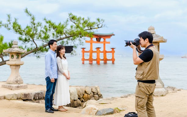 Photographer capturing a couple near the Torii gate at Miyajima, Japan.