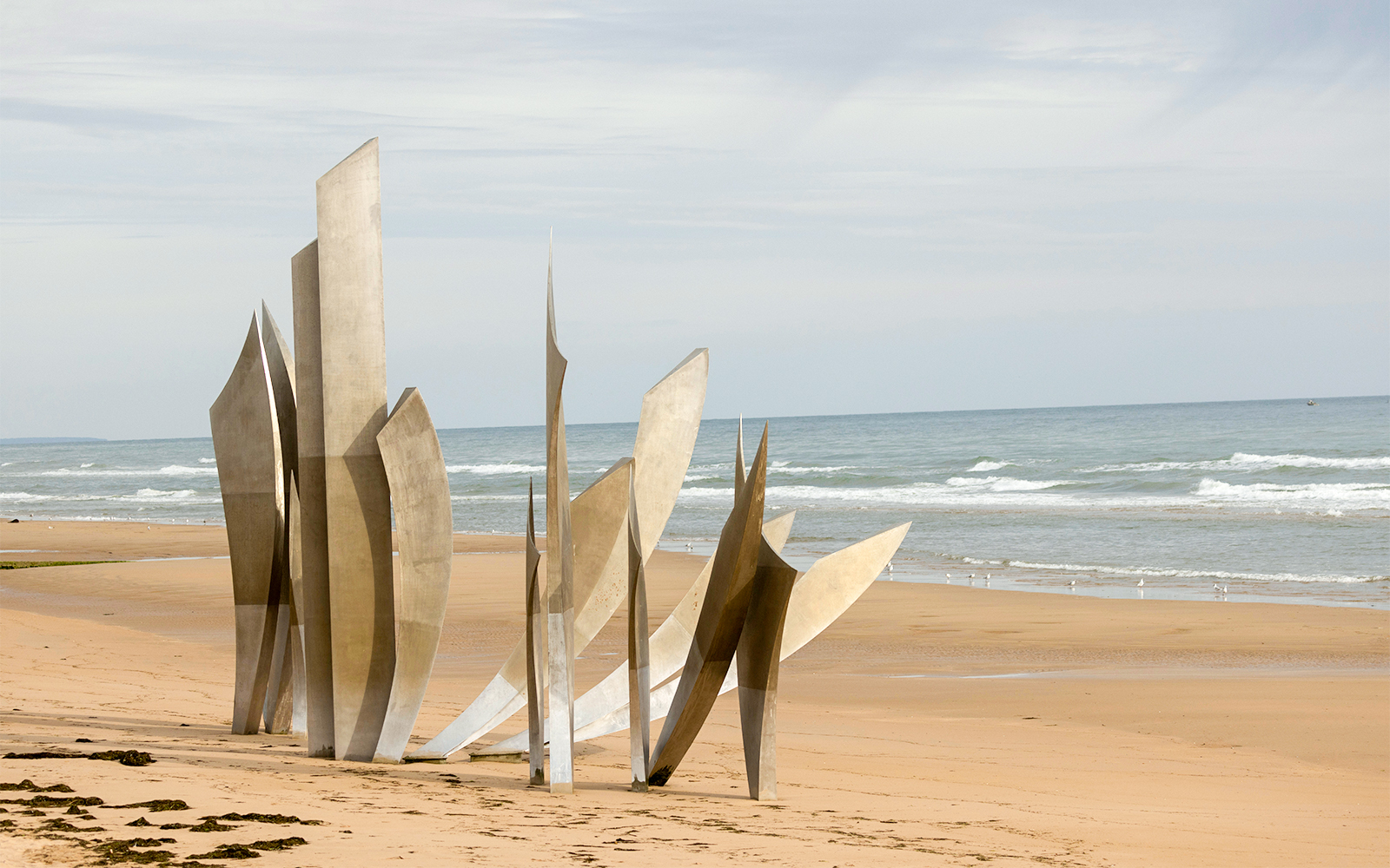 Normandy D-Day Tour visitors exploring Omaha Beach memorial site in France.