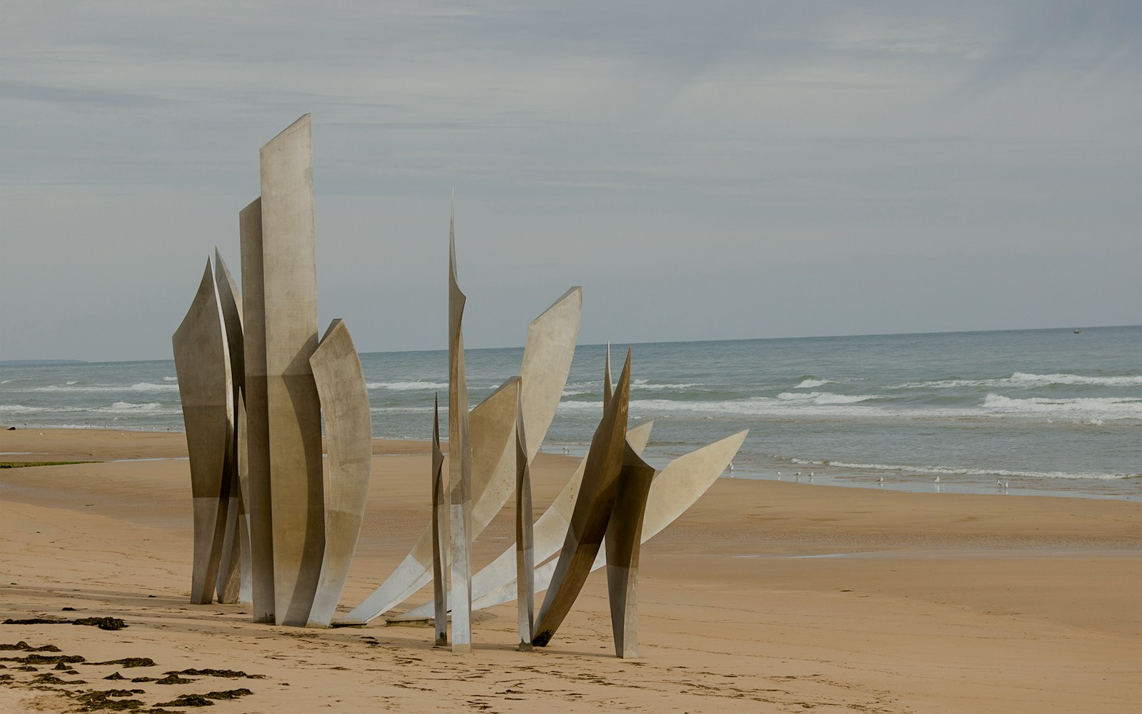 Normandy D-Day Tour visitors exploring Omaha Beach memorial site in France.