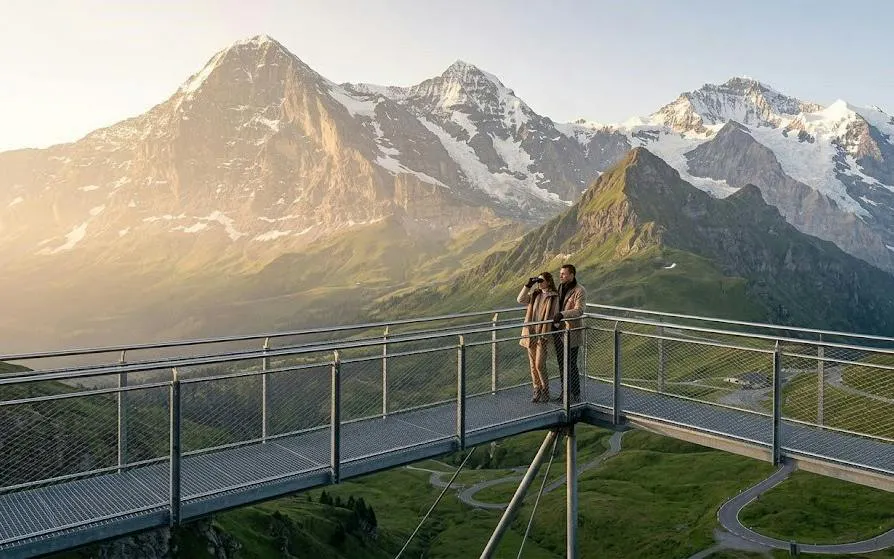 Visitors on a viewing platform overlooking the Swiss Alps in Grindelwald, Switzerland.