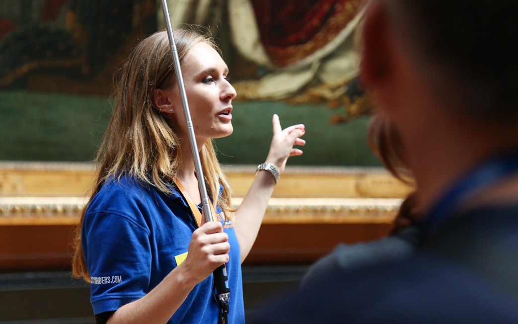 Guide leading a small group on a VIP tour inside the Louvre Museum, Paris.