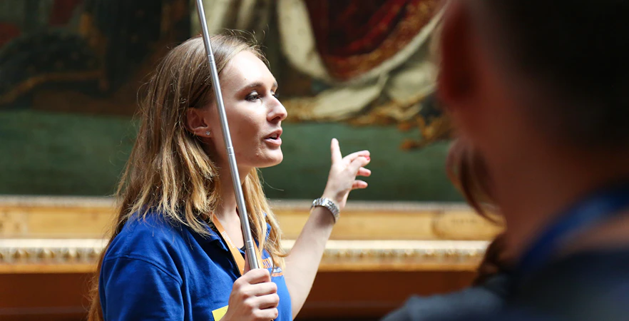 Guide leading a small group on a VIP tour inside the Louvre Museum, Paris.