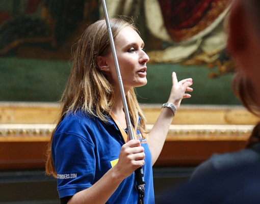 Visitors on a VIP guided tour inside the Louvre Museum, viewing famous artworks with skip-the-line access in Paris.