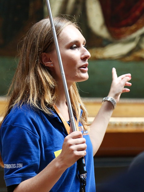 Guide leading a small group on a VIP tour inside the Louvre Museum, Paris.