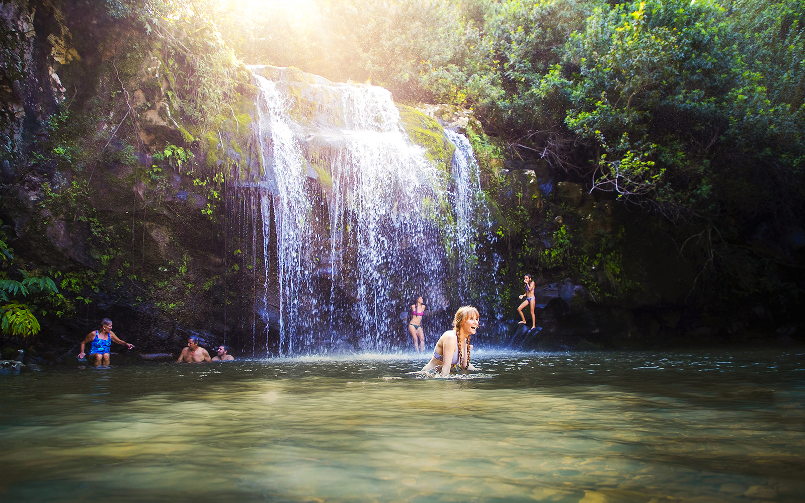 Guests enjoying a waterfall swim on the Kohala Zip & Dip tour in Hawaii.