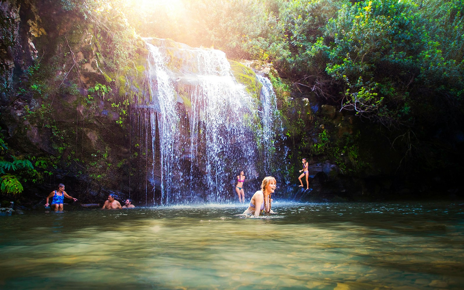 Guests enjoying a waterfall swim on the Kohala Zip & Dip tour in Hawaii.