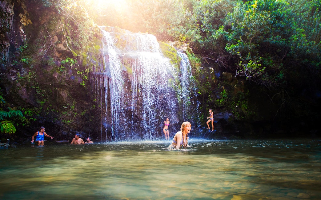 Guests enjoying a waterfall swim on the Kohala Zip & Dip tour in Hawaii.