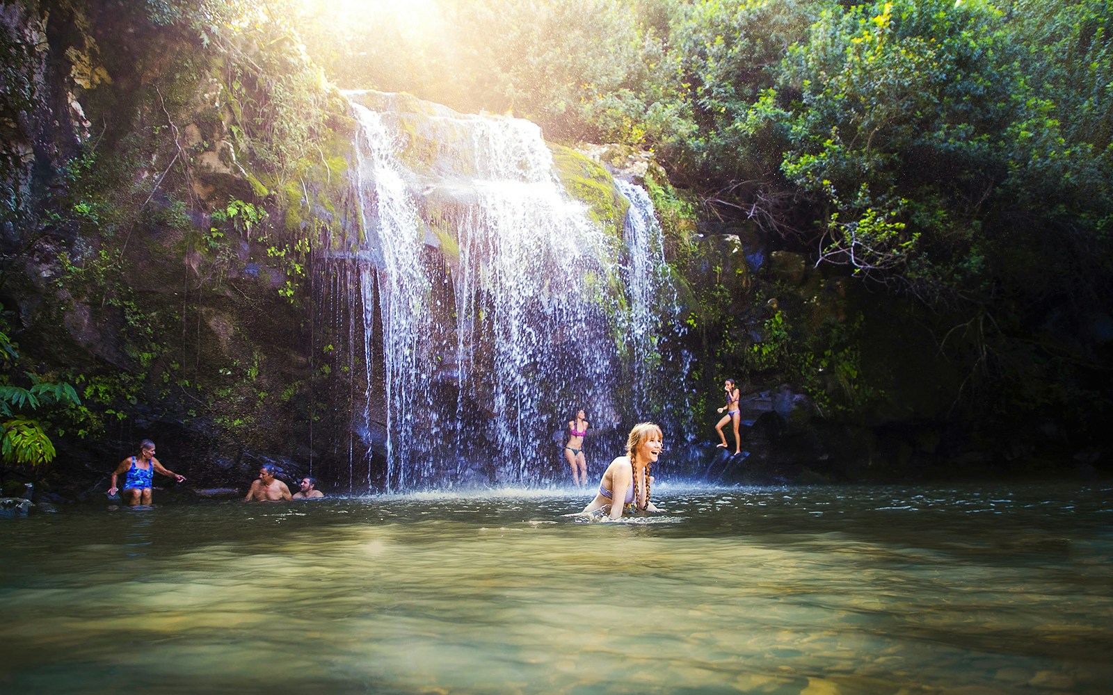 Guests enjoying a waterfall swim on the Kohala Zip & Dip tour in Hawaii.