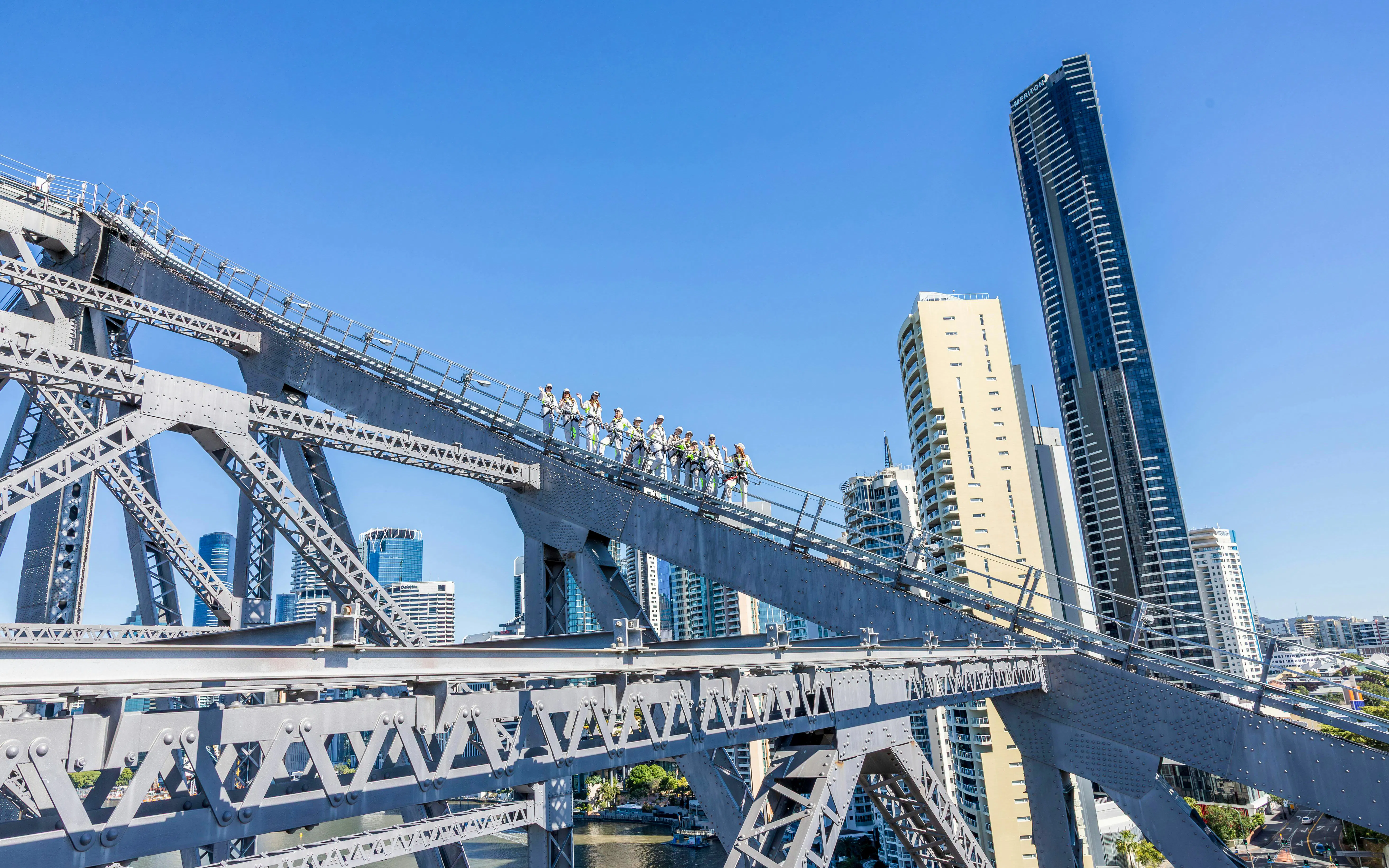 Climbers on Story Bridge with Brisbane skyline in the background.