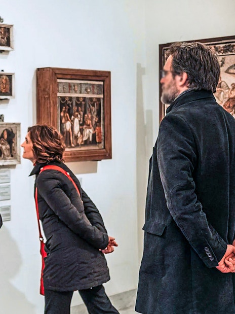 Visitors examining ancient frescoes at Naples National Archaeological Museum.