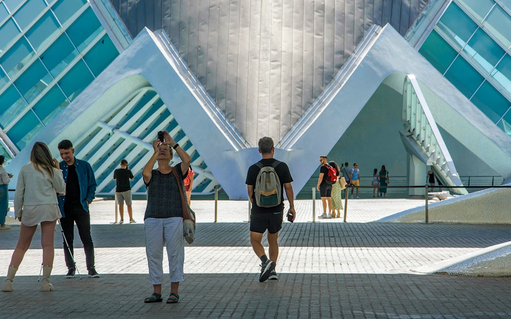 Visitors at Hemisfèric in Valencia, Spain, capturing photos of the modern architecture.
