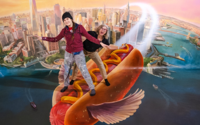 Guests posing on a flying hot dog at TiLT Interactive Museum, American Dream.