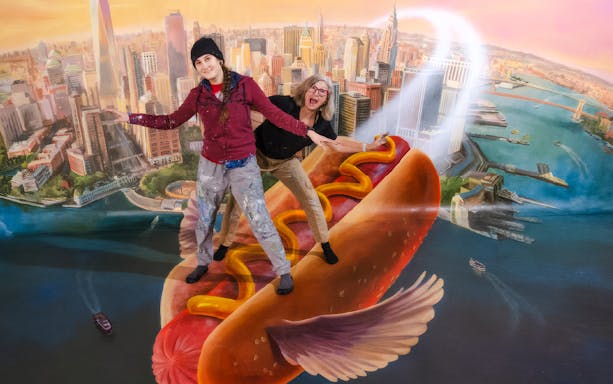 Guests posing on a flying hot dog at TiLT Interactive Museum, American Dream.