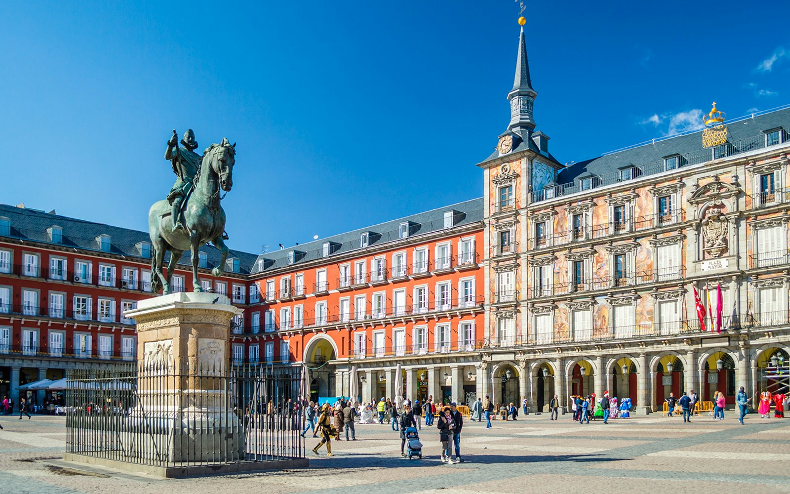 Equestrian statue in Plaza Mayor, Madrid with surrounding historic buildings.