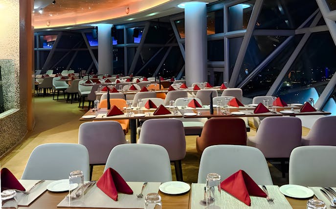 Dining setup at Orbit Revolving Restaurant, KL Tower, Kuala Lumpur, with city skyline view.