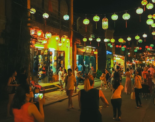 Hoi An Night Market with colorful lanterns and bustling crowd.