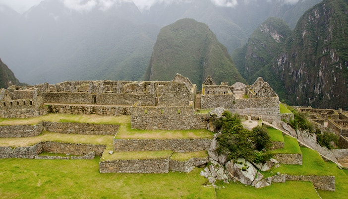 Ancient stone ruins of Machu Picchu with misty mountains in the background, Peru.